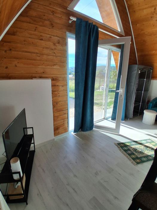Cameră cu televizor și ușă spre balcon